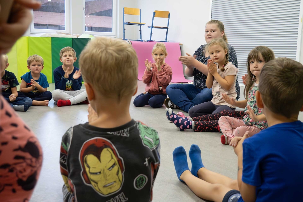 Kinder klatschen, sitzen im Kreis | Kinderbetreuung | Kinderwerkstatt Hargassner