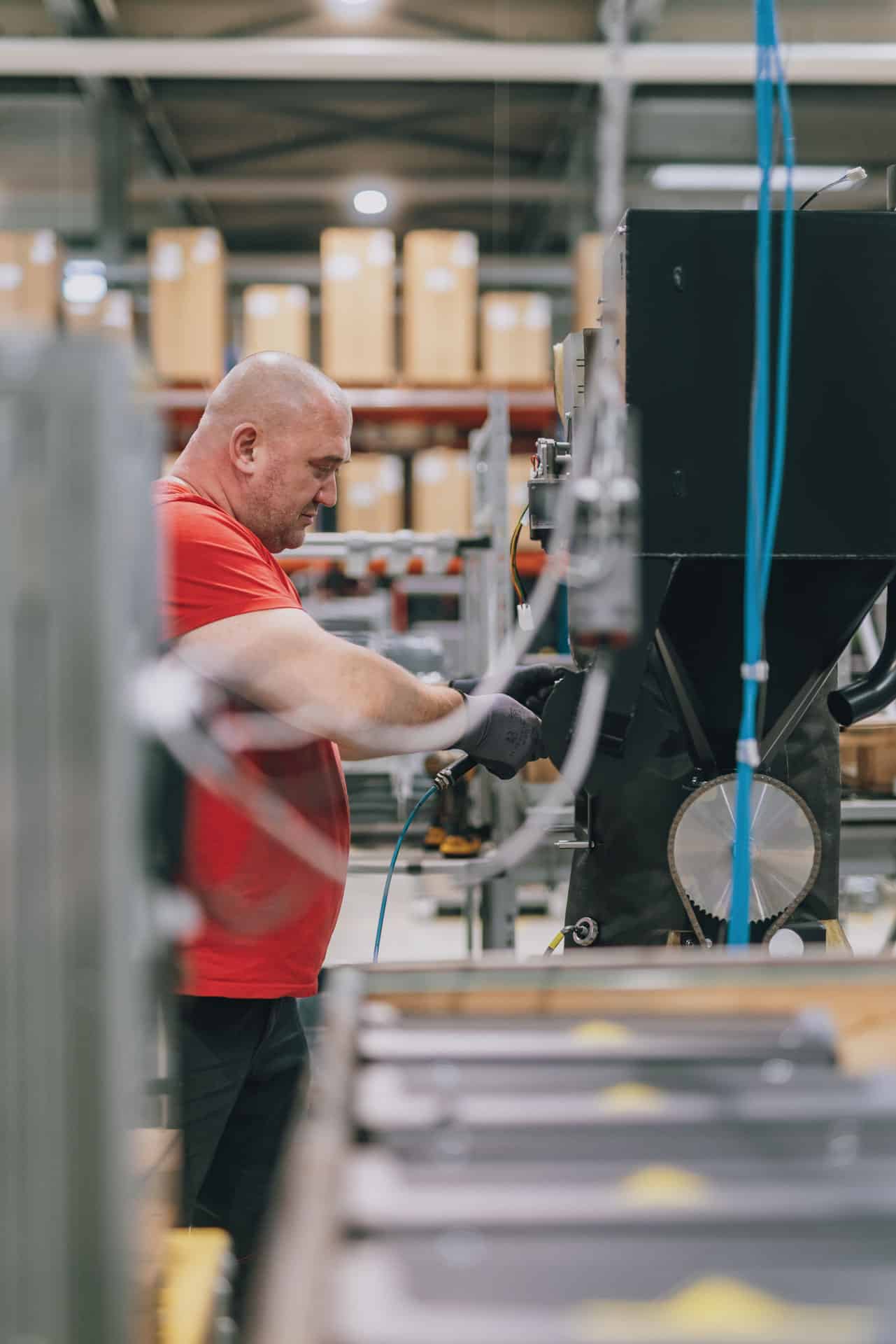 Symbolbild Abeiltung Produktion - Mann arbeitet an Produktionslinie