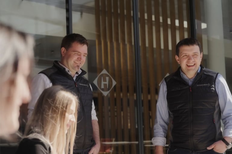 Hargassner Geschäftsführer Markus und Anton plaudern im Innenhof mit Mitarbeitern, gelbte Du-Kultur
