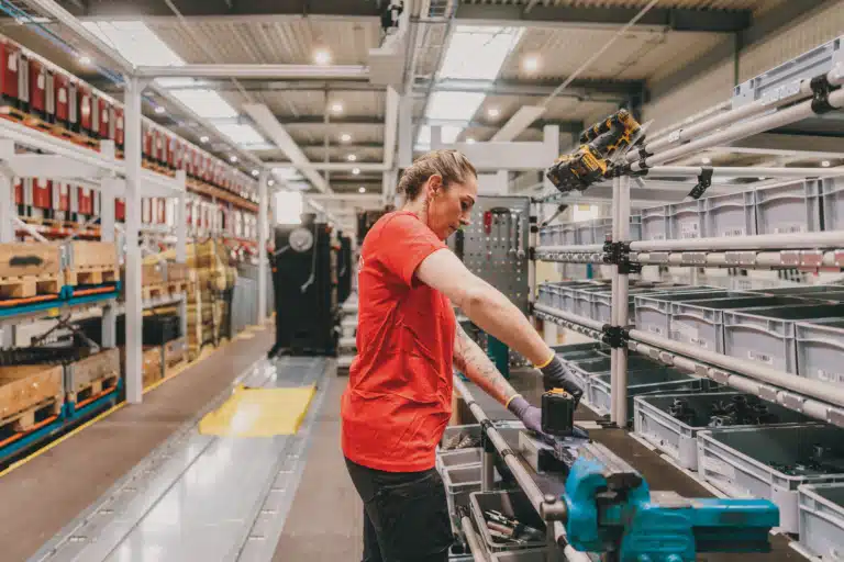 Symbolfoto für Abteilung Produktion. Frau arbeitet bei Montagelinie